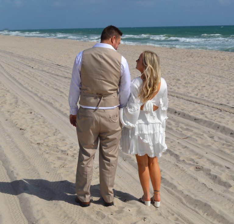 Bride & groom together, with groom giving a kiss on the cheek to his bride in Miami Florida