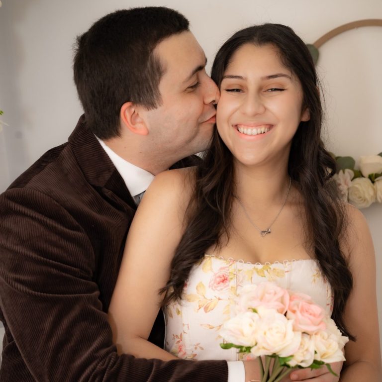 Bride & groom together, with groom giving a kiss on the cheek to his bride in Miami Florida