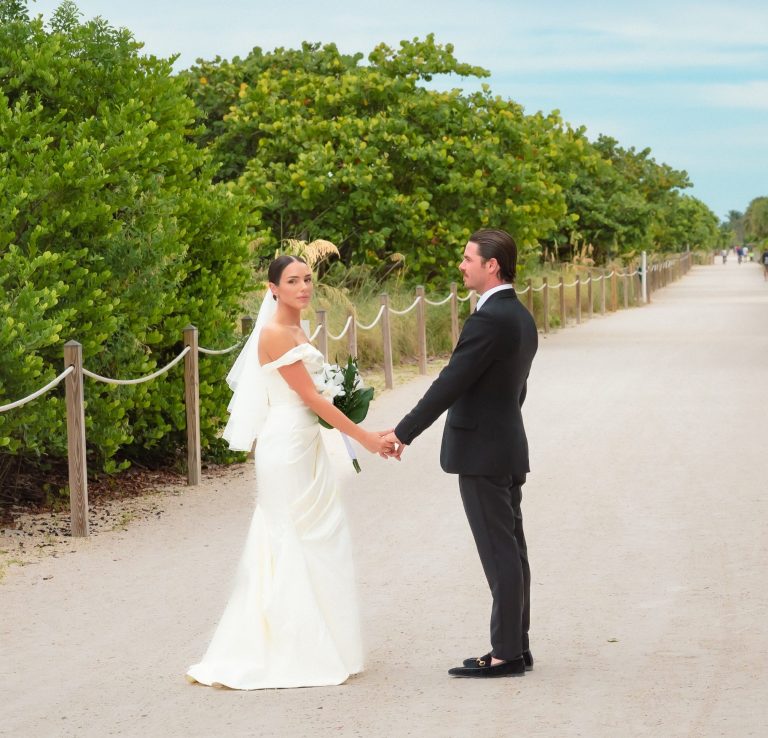 Bride & groom holding hands on a path in Miami Beach Florida.