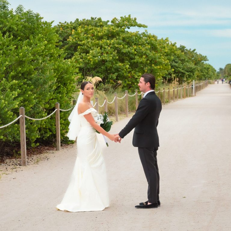 Bride & groom holding hands on a path in Miami Beach Florida.