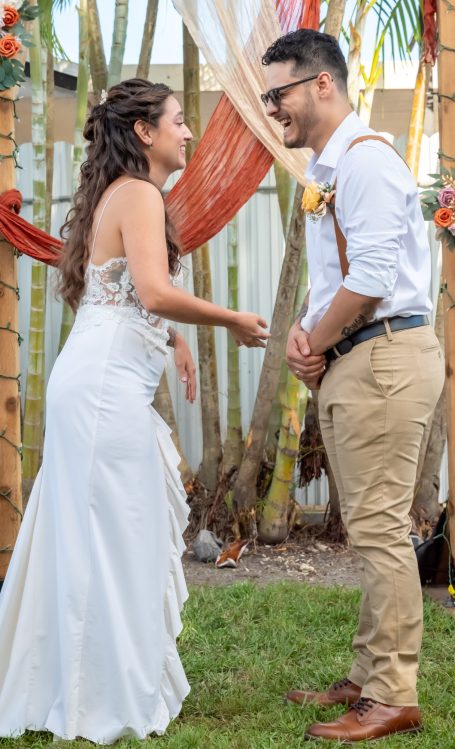 Bride and groom sharing vows in a decorated outdoor setting with Iris Ramil from WeddingDayRomance
