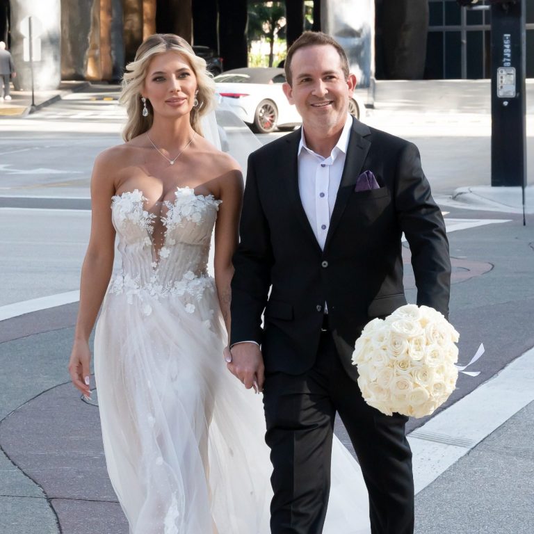 Bride in a flowing gown and groom in a suit, walking hand in hand across The W Hotel on Brickell Avenue