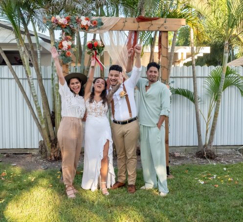 A happy group of wedding guests in Miami in a backyard with bride & groom.