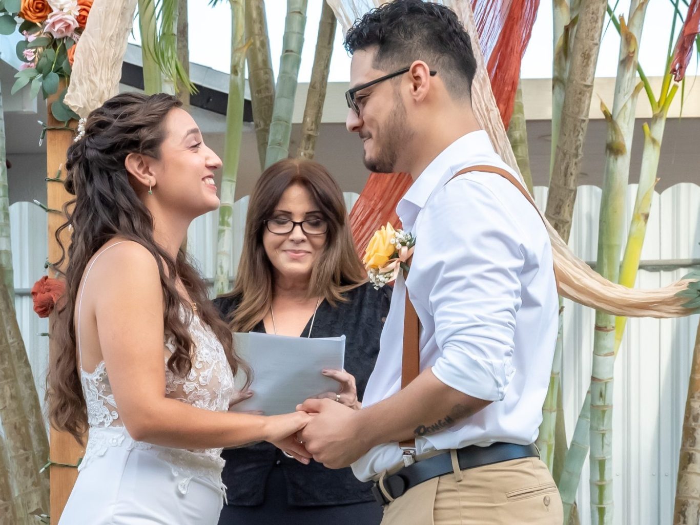 Wedding Officiant Iris Ramil Smiling couple exchanging vows at an outdoor wedding ceremony.