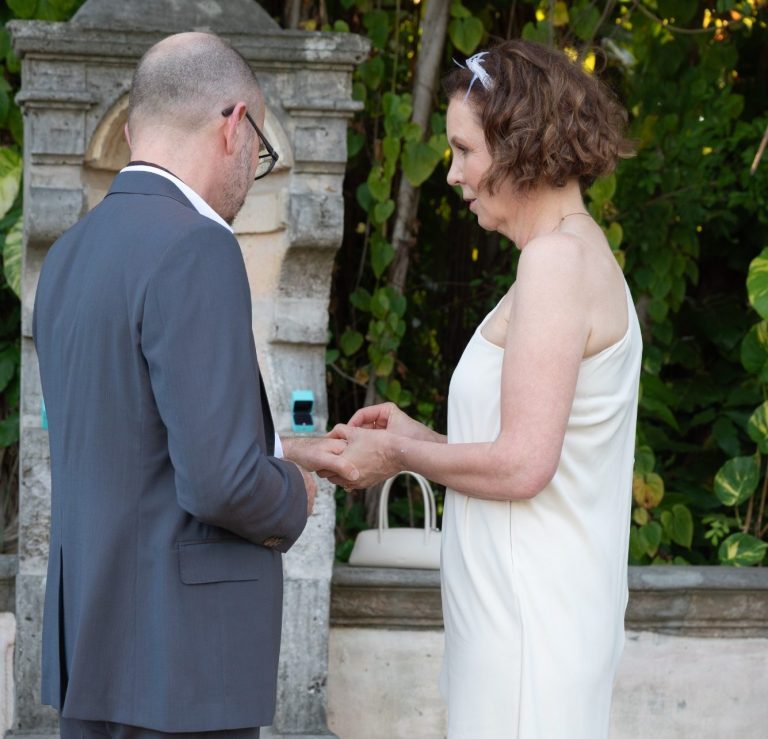 Couple kissing while holding hands in Pinecrest Florida by Iris Ramil Photographer and Wedding Officiant