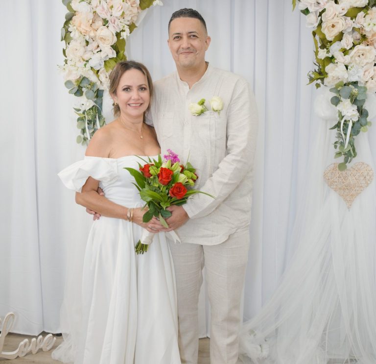 Bride & groom stand together, surrounded by wedding arch at Ceremony Suite from Wedding Day Romance Miami