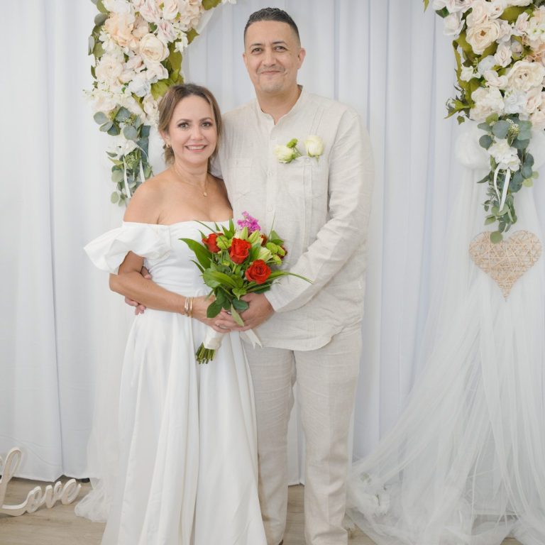 Bride & groom stand together, surrounded by wedding arch at Ceremony Suite from Wedding Day Romance Miami