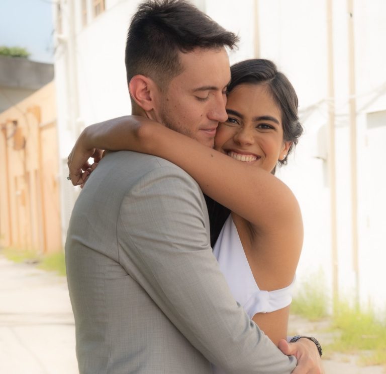 Bride and groom holding each other tight and smiling outdoors at Wedding Day Romance.