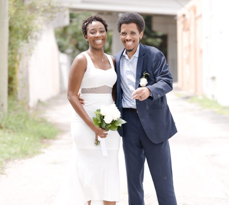 Bride & Groom smiling at Iris Ramil Photographer Bride & Groom standing together on a pathway in Key Largo, Florida