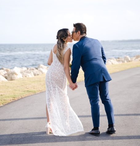 Couple in a romantic embrace, walking hand in hand by the waterfront.